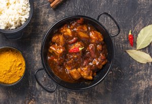 Savory Galinha ao Molho Pardo, a traditional Minas Gerais chicken dish featuring a rich sauce made from blood, vegetables, and spices.